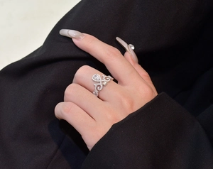 Detailed macro view of 925 silver crown ring with micro-pave diamonds and pear-cut stone