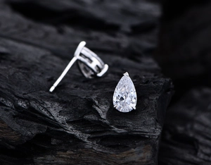 Macro shot of S925 sterling silver pear cut ear studs with sparkling carbon diamonds