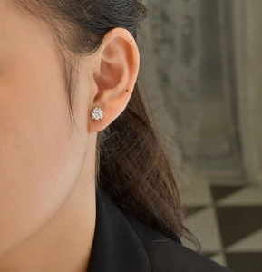 Close-up of classic 925 sterling silver snowflake stud earring with brilliant round diamond