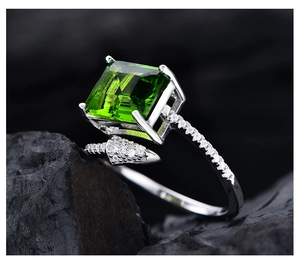 Dettaglio macro di un anello a freccia in argento con grande pietra verde quadrata taglio smeraldo