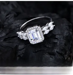 Macro detail of emerald-cut white zirconia silver ring on a dark textured background