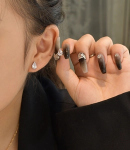 Detail of pear-shaped teardrop cubic zirconia earrings worn by a model with elegant nails