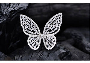 Detailed macro shot of a butterfly ring with silver base and baguette-cut zircon stones