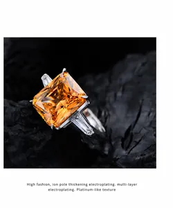Vista macro de anillo con gema naranja de 10,5ct sobre fondo de piedra mineral negra