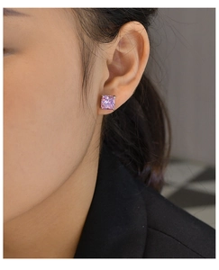 Detail of rose pink cushion cut carbon diamond earring in 925 silver setting on model