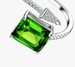 Dettaglio anello con gemma verde rettangolare e design a freccia con pavé di diamanti