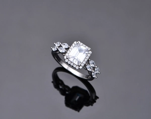 Macro view of emerald-cut white zircon ring with S925 silver stamp and halo setting