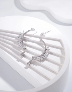 Macro detail of S925 silver feather earrings with sparkling marquise-cut crystals