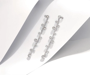 Macro detail of silver long linear tassel earrings with sparkling cubic zirconia stones