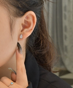 Close-up of S925 silver pear cut cubic zirconia stud earrings worn by a model