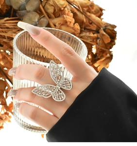 Macro shot of silver butterfly ring with cubic zirconia inlay on a glass surface