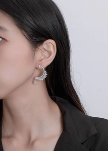 Macro view of S925 silver feather ear cuff with shimmering crystals and leaf patterns