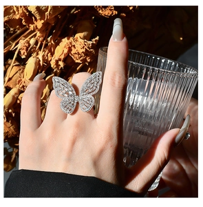 Close-up of a large silver butterfly ring with shimmering baguette and round zircons