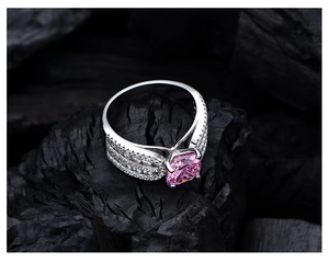 Detail eines Ringes mit rosa Edelstein im Prinzessschliff und Pavé-Besatz auf Silberband