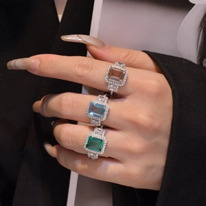 Three emerald cut crystal rings in champagne, blue and green with halo setting