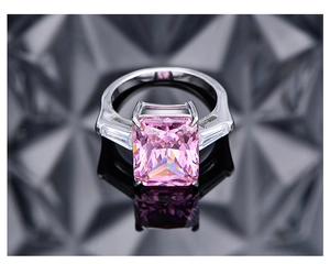 Vista macro de anillo con gema rosa de 10,5 ct corte radiante y diamantes sobre base reflectante