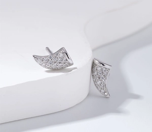 Détails macro des boucles d'oreilles en argent en forme de corne serties de zircones