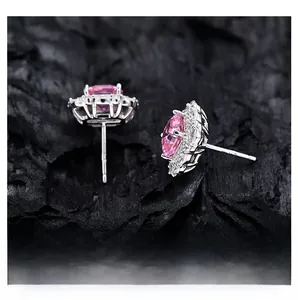 Detailed view of pink halo stud earrings with asscher cut stone on black textured rock
