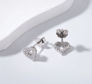 Macro detail of silver heart stud earrings with sparkling cubic zirconia pavé