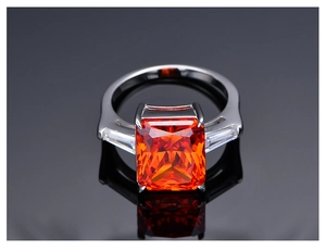 Vista macro de un anillo de plata 925 con una gran gema naranja de corte radiante y piedras laterales