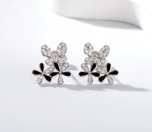 Detail of S925 silver butterfly studs with black enamel petals and zircon pavé