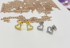 Close-up of S925 sterling silver heart earrings with sparkling cubic zirconia in gold and silver