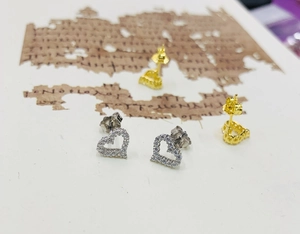 Detail of silver and gold heart stud earrings with cubic zirconia pave setting