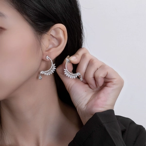 Elegant S925 silver feather-shaped earrings with zircon crystals on an Asian model