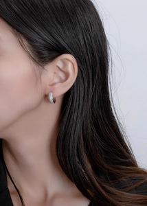 Macro detail of S925 sterling silver hoop earrings with triple-row micro-pave zircons