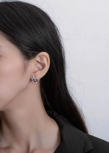 Detail view of S925 silver butterfly petal stud earrings with white and black enamel
