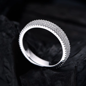 Sparkling 925 sterling silver ring with three rows of pavé zircons on black rock background