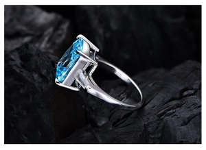 Détail d'une bague en argent S925 avec pierre bleue marquise et diamants latéraux