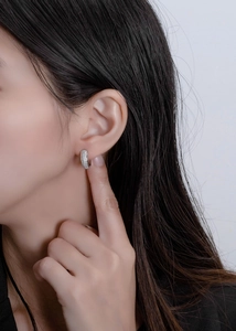 Detail of 925 sterling silver hoop earrings with pavé set white cubic zirconia stones