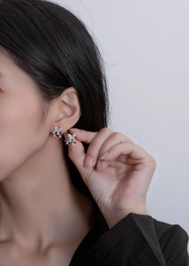 Elegant triple butterfly earrings in black and white worn by a model in a close-up profile