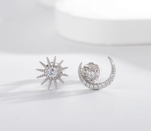 Macro view of asymmetrical S925 sterling silver sun and moon stud earrings with zircons