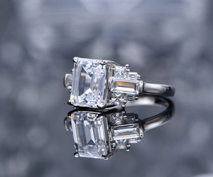 Macro view of emerald cut gemstone with side baguette diamonds on S925 silver ring