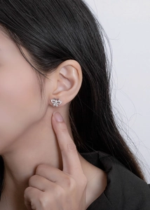 Macro view of crystal butterfly stud earrings with micro-pave setting on ear