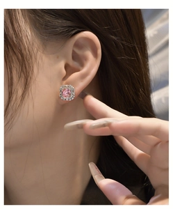 Macro detail of luxury pink radiant cut halo stud earrings in 925 sterling silver