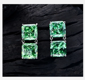 Macro shot of 8ct square ice-cut green gems set in S925 silver studs on black charcoal