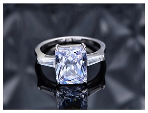 Vue macro d'une bague diamant taille radiant 10,5 ct avec pierres baguette sur miroir