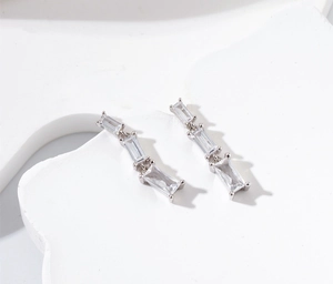Détail de boucles d'oreilles pendantes en argent serties de zircons coupe baguette