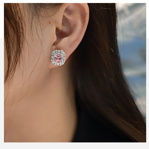 Macro detail of luxury emerald cut pink stone earrings with double halo setting