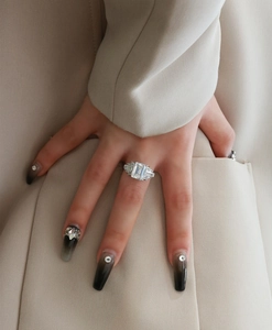 Close-up of emerald cut gemstone ring with baguette side diamonds on hand