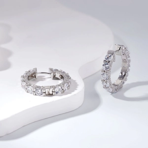 Boucles d'oreilles créoles en argent 925 avec zircons sertis sur présentoir blanc