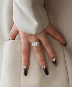 Detail of emerald-cut high carbon diamond ring in S925 silver on hand with suit