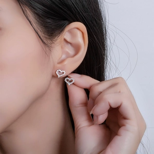 Sparkling S925 sterling silver heart stud earrings with cubic zirconia on female model
