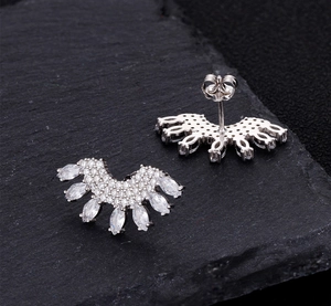 Macro view of fan-shaped silver earrings with sparkling zircons and butterfly clasp back