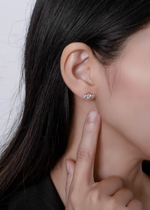 Close-up of three-stone S925 sterling silver studs worn by a model in profile