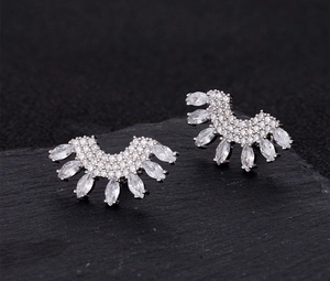 Macro shot of silver fan-shaped earrings with micro-pave zircons and marquise cut details