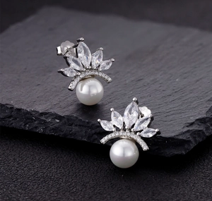Macro view of S925 silver crown pearl earrings with marquise cubic zirconia detail